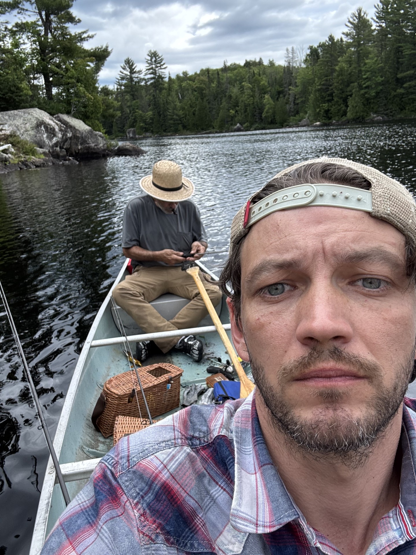 Two men in a canoe on a backcountry lake with fishing gear